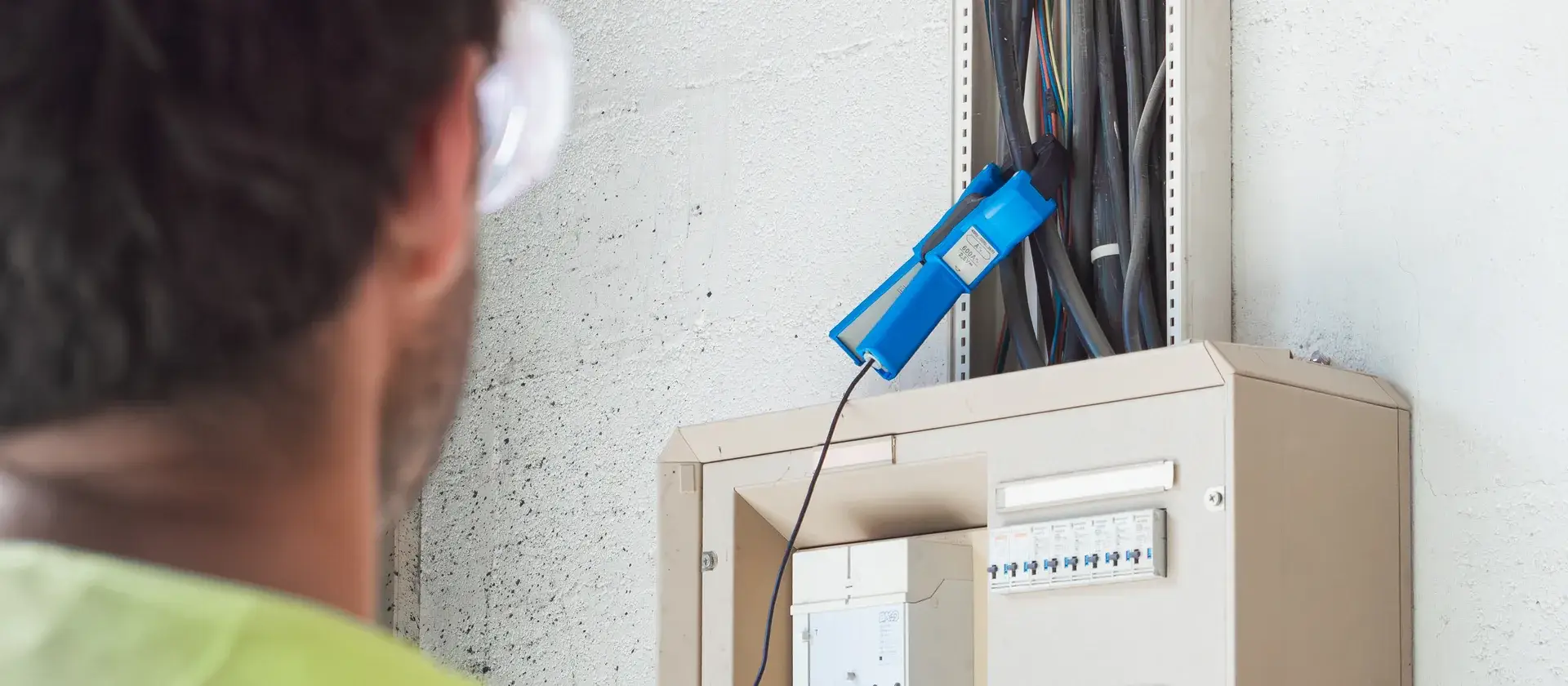 Mesure à la pince ampèremétrique sur une armoire électrique lors d'un audit énergétique